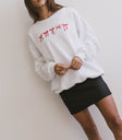 white sweater with red ribbons