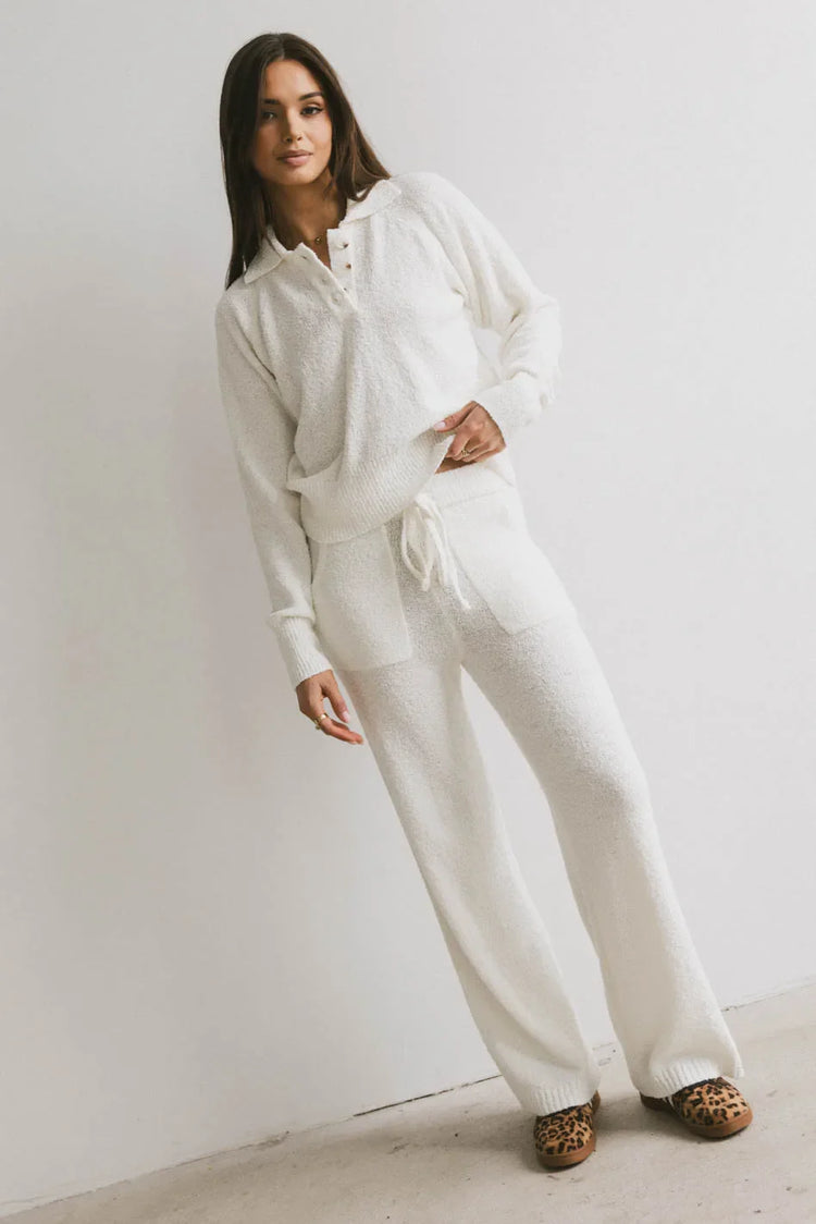 Pants paired with a cream sweater