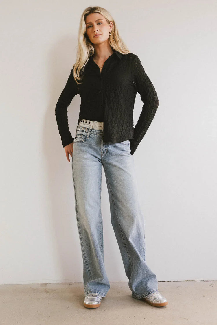 Button up top in black paired with light denim jeans
